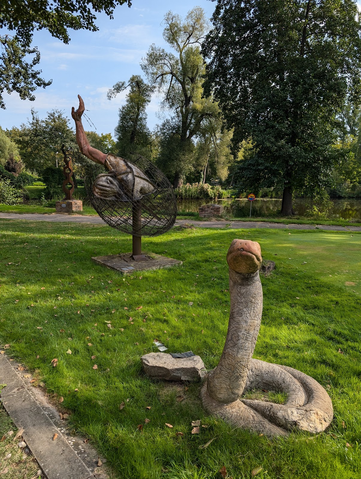 Dom klubowy i otoczenie pola golfowego A&A Arkadia w Pabianicach - drewniana zabudowa, parasole, miejsca do siedzenia, zieleń i drzewa